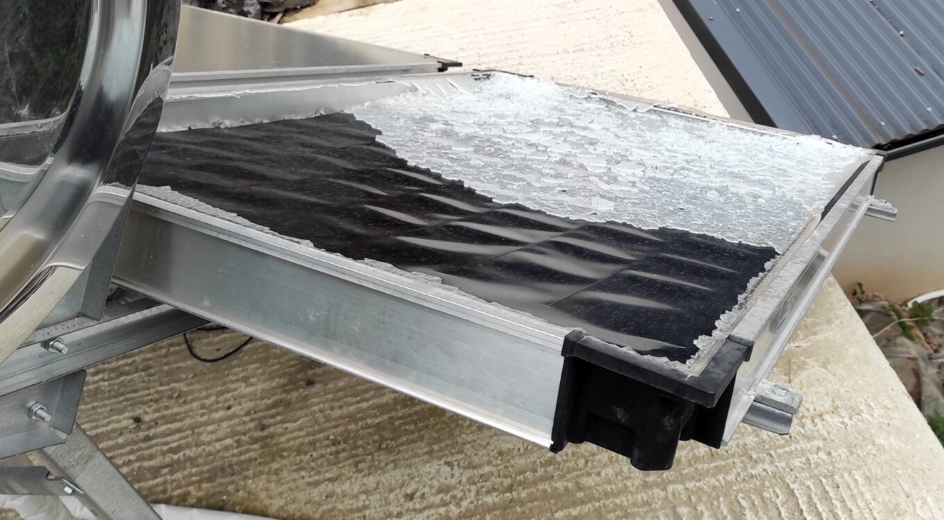 Broken solar water heater collector damaged by hail storm.